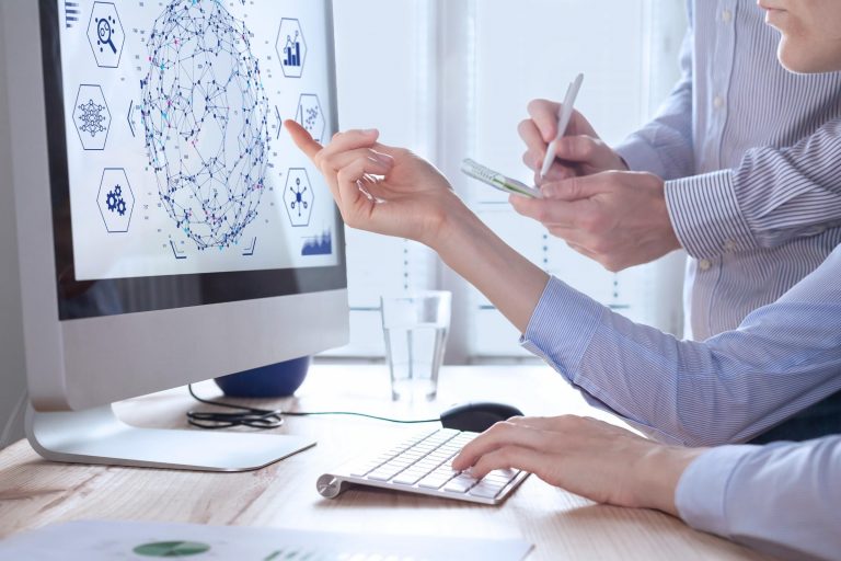 Two data scientists looks the daha network on the monitor